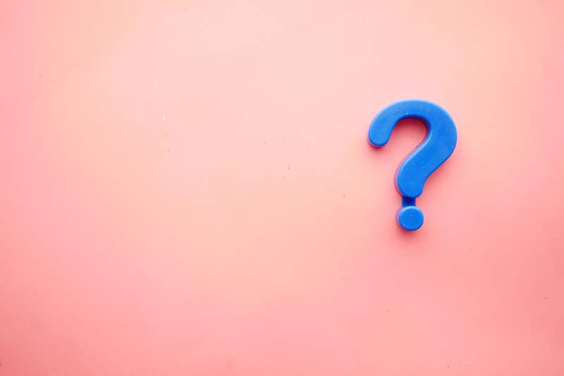 A question mark on a pink background supposed to represent FAQ about AFrican importing, exporting, and brokering and how TRAGOA can help answer and solve them for members