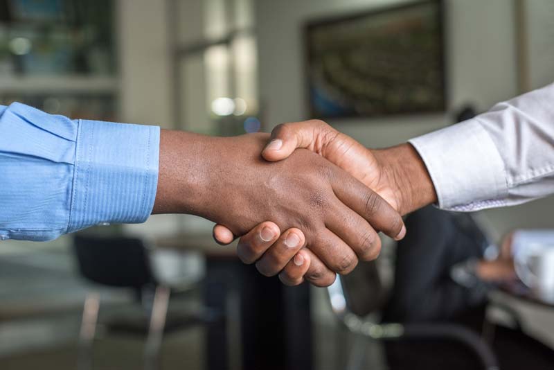 An image of two African B2B business trade partners shaking hands after finding business on the best African B2B marketplace platform online which is tragoa.com