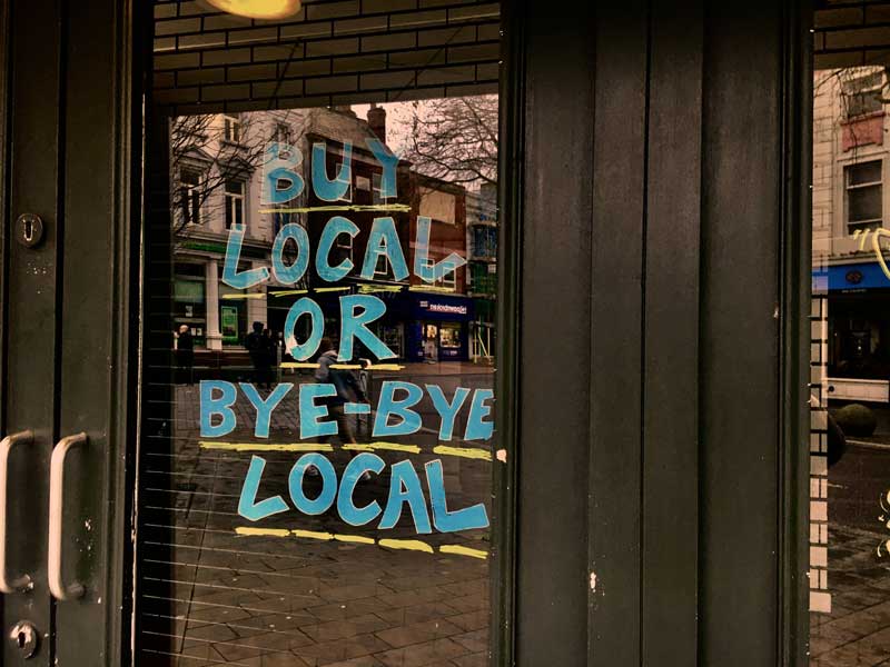 An image of an African store sign that says buy local or bye bye local which is what will happen if you don't register for the free AFrican B2B marketplace TRAGOA.com and support localization in Africa with importing, exporting, and brokering