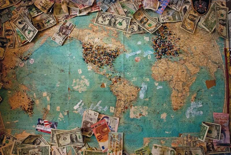 An image of money around a map of the world including Africa which signifies that you will get money around the world if you find money for your African business and products and logistics and supply chain through TRAGOA.com and their partner Jetstream Africa
